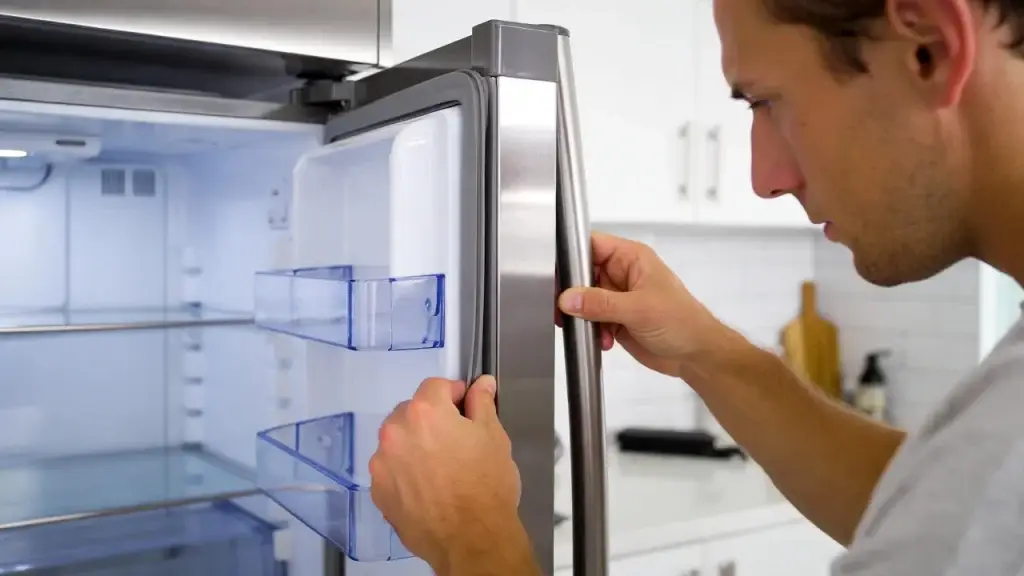 homeowner repairing a refrigerator door gasket 